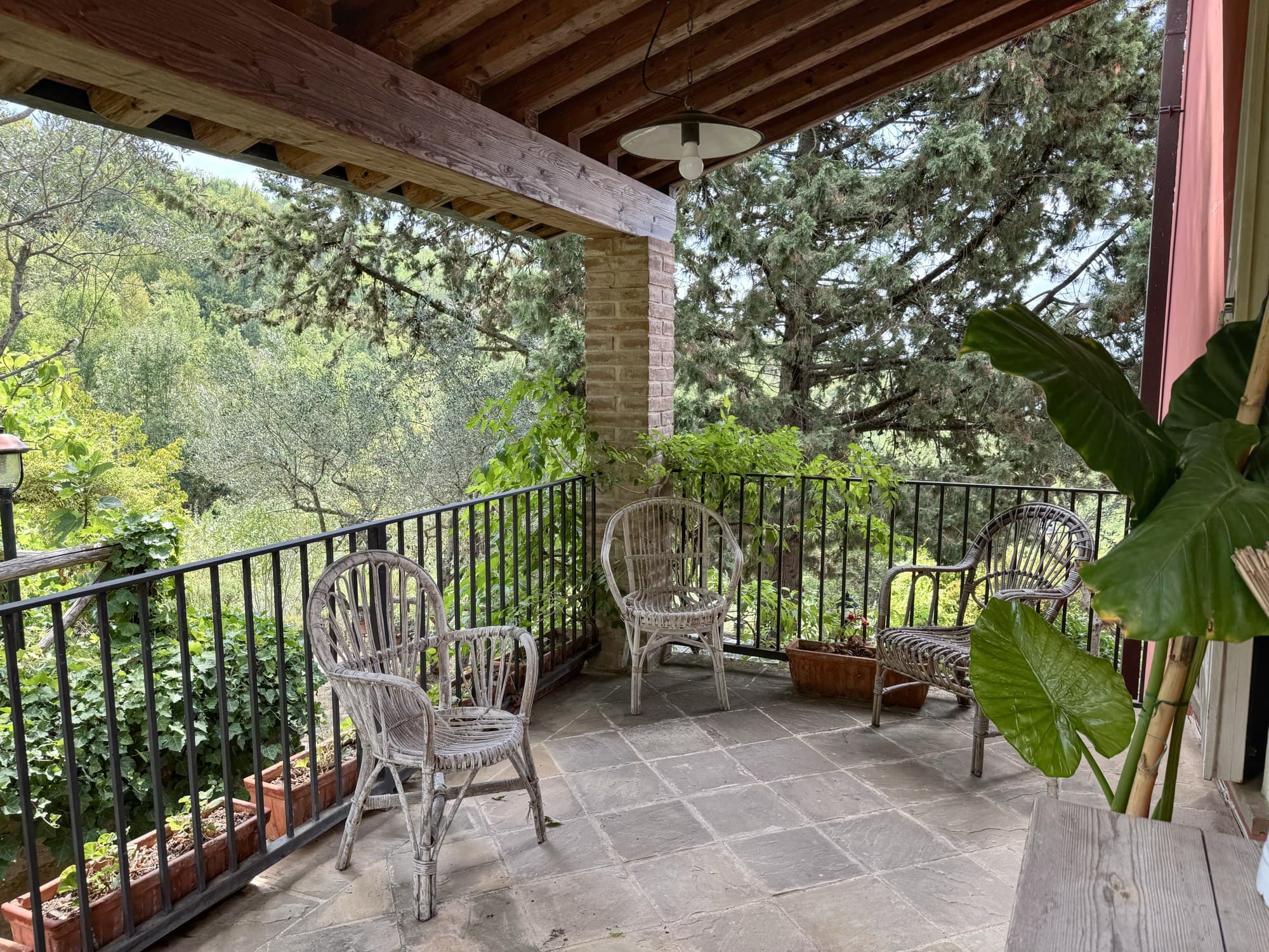 La loggia con le poltrone di vimini, affacciata sul verde