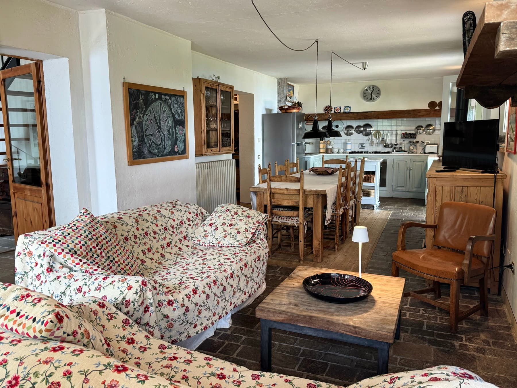 Il soggiorno aperto sulla cucina, con il divano e il tavolo da pranzo