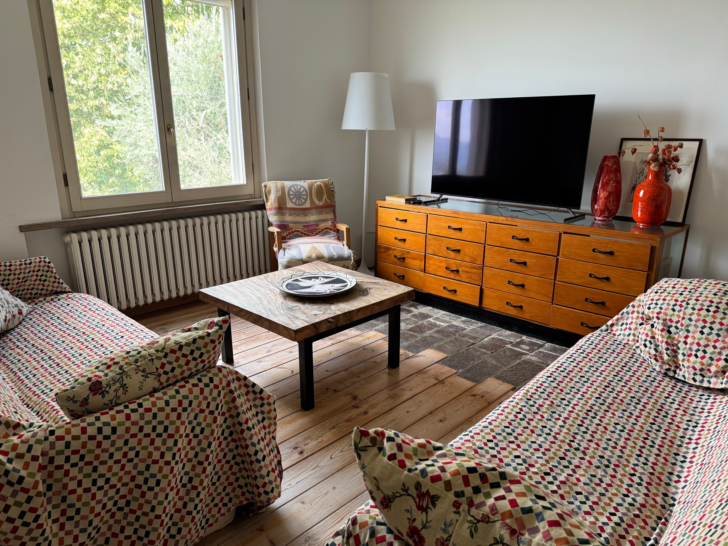 Il salotto relax con il divano, la televisione e la cassettiera in legno