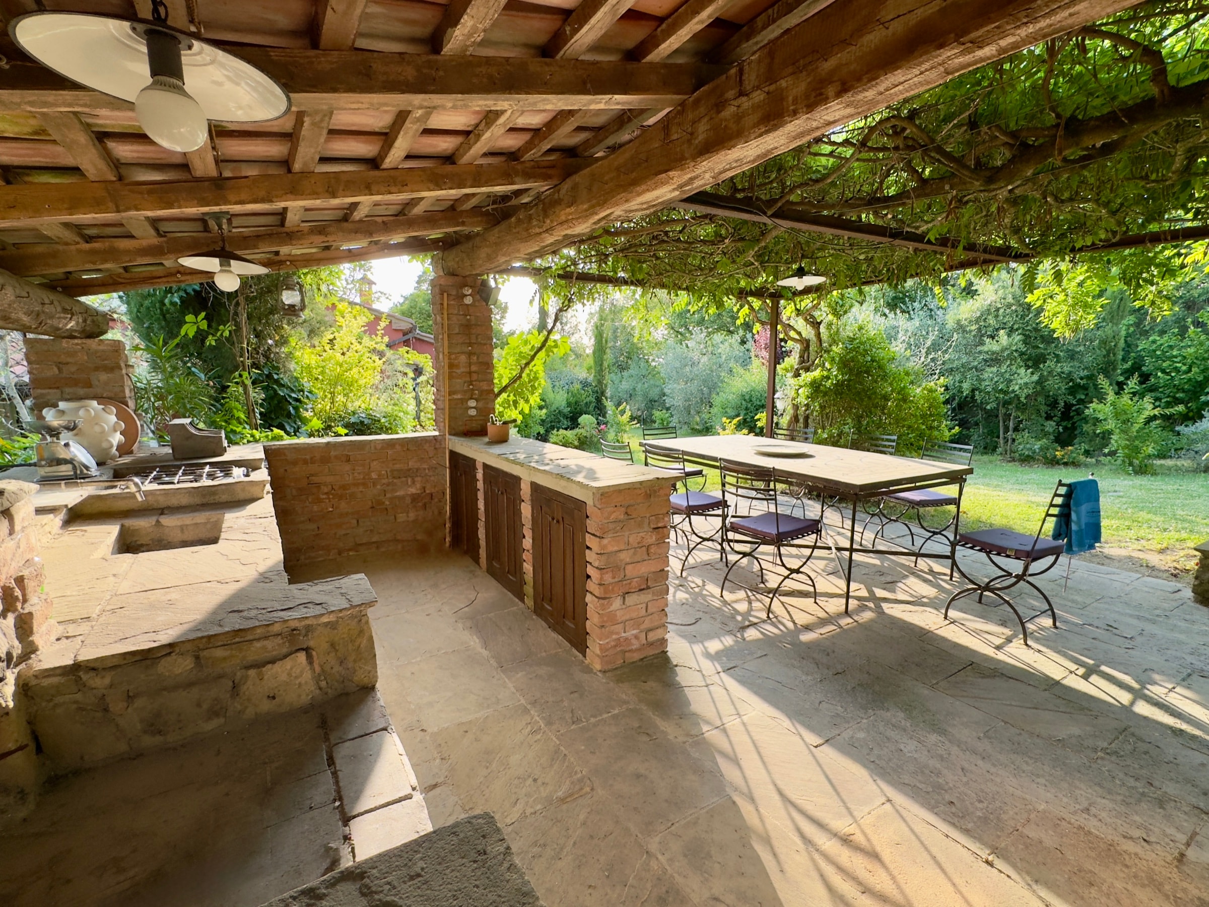 La cucina esterna sotto il portico, aperta sulle colline