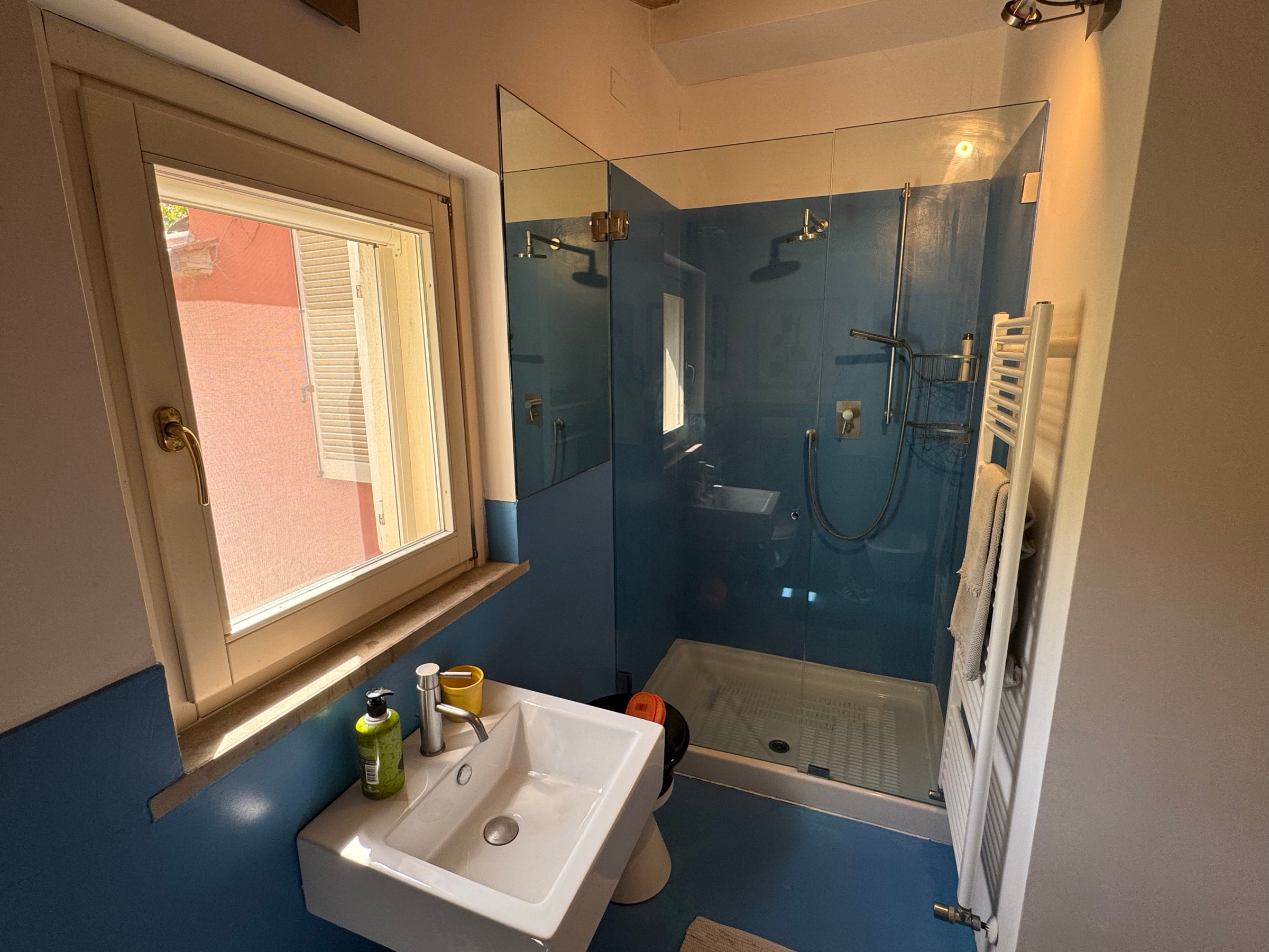 La doccia del bagno in camera, con la parete blu